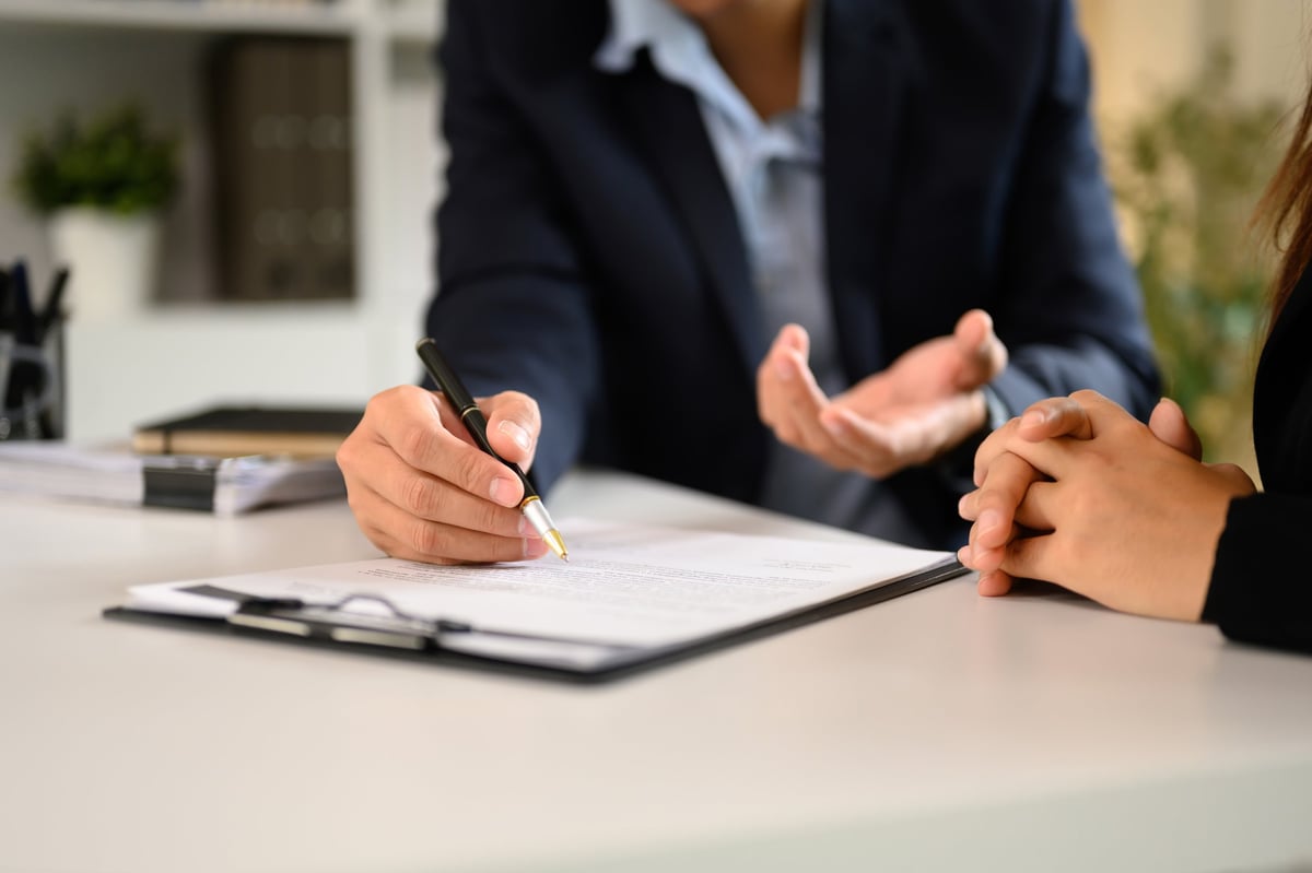 Business professionals finalising tender and contract documents at a desk
